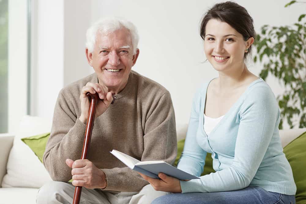 Female vounteer reading to senior